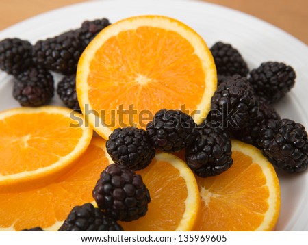 Plate of sliced navel oranges and fresh blackberries