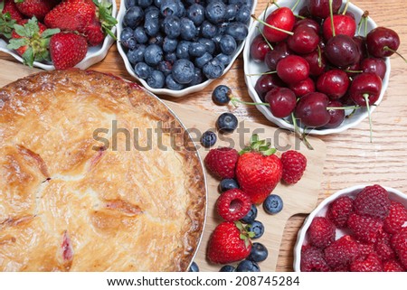 Variety of berries garnish a golden delicious freshly baked country-style dessert berry pie.