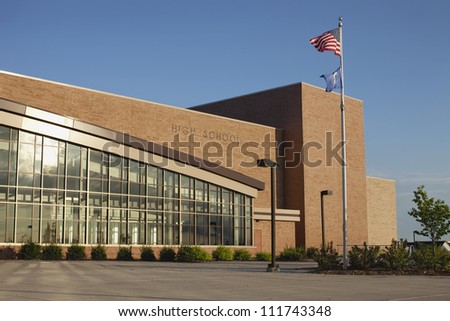 Modern high school on bright summer morning with flag flying