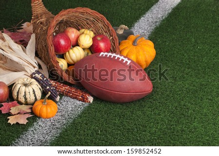 A football with a cornucopia on a grass field with white stripe
