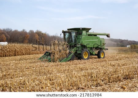 WEST ALBANY, MINNESOTA, USA - October 12, 2010: A farmer harvests corn in a John Deere combine. John Deere is a major manufacturer of agricultural machinery.