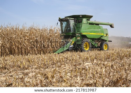 WEST ALBANY, MINNESOTA, USA - October 12, 2010: A farmer harvests corn in a John Deere combine. John Deere is a major manufacturer of agricultural machinery.