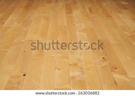 A basketball court floor made of maple hardwood viewed at a low angle