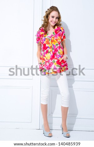 Full length young fashion model posing standing and looking in camera