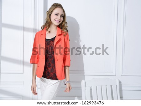 portrait of fashion model with chair standing posing in studio
