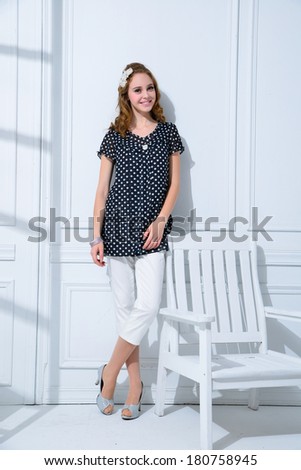 Full body fashion model with ladder, chair posing in the studio