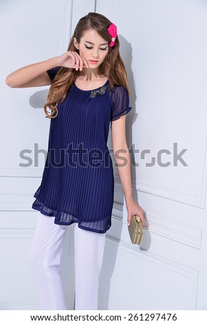 portrait of a beautiful young female with handbag standing posing