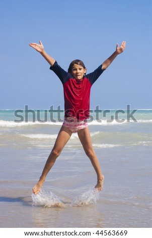 Joyous girl jumping on the background of the ocean