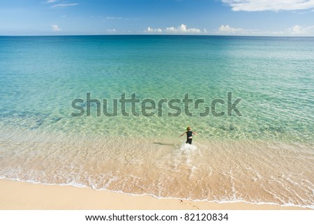 A little boy wearing a mask and a tube runs into the desert ocean