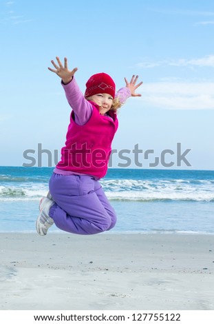 Girl joyfully jumping on background of ocean