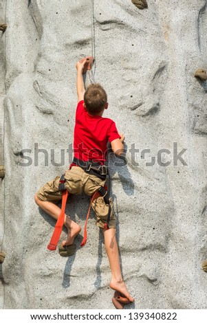 A child climbs on a rock-climbing wall - Tower