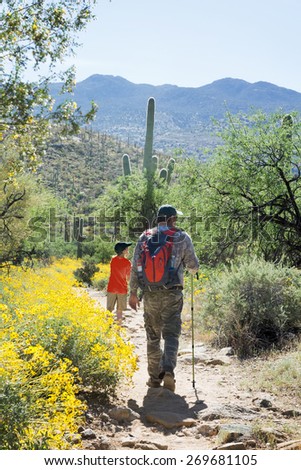 Father and son are traveling on foot through the Sonoran Desert. Saguaro National Park, Arizona, USA