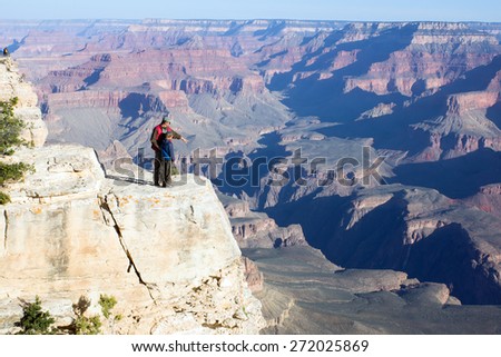 Father with child stand on a cliff. Adult explains how formed the Grand Canyon in Arizona