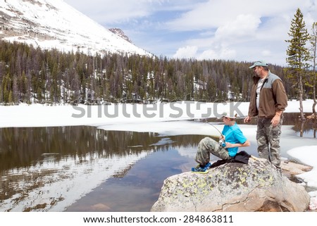 The child caught a fish in a mountain lake. Father ready to help.  Mirror Lake,  Uinta-Wasatch-Cache National Forest, Utah