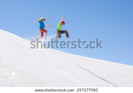 Children jumping with bare feet down the dune. National Monument \
