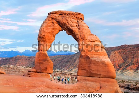 A group of people (two families with children) joined hands and raised them. Arches National Park, Utah