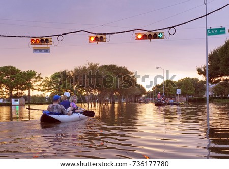 Working traffic lights over flooded Houston streets and boats with people at sunset. Texas, USA