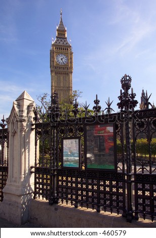 Westminster with big ben above the railings.  A red London bus is reflected in the poster.