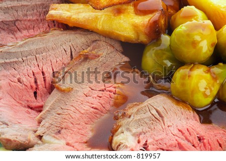 Roast Beef Dinner, landscape format.  A delicious traditional hot roast dinner with tender rare beef, sprouts, parsnips roast potatoes and gravy.
