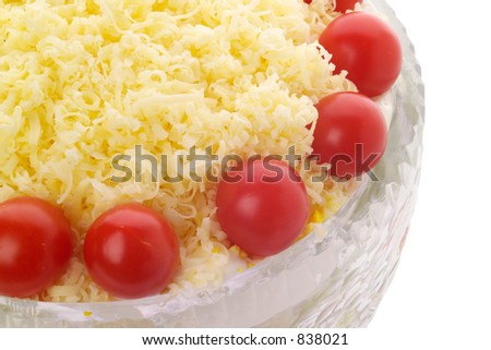 Cheese and cherry tomato topped salad in crystal bowl