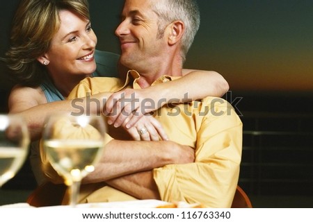 Relaxed couple sitting enjoying a glass of wine together share a special moment of affection and love