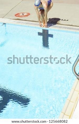 Female swimmer preparing to jump in swimming pool