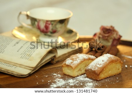Antique book, tea cup and cakes