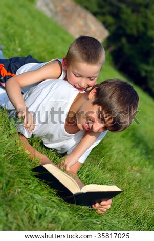teenager and kid with a book