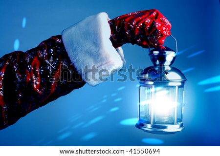 The hand of Santa Claus holds a lamp