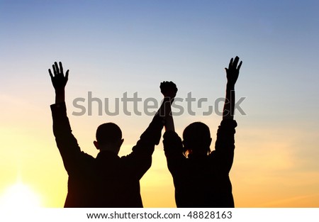 Friends silhouette on sunset background