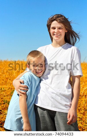 happy brother and sister in the summer field