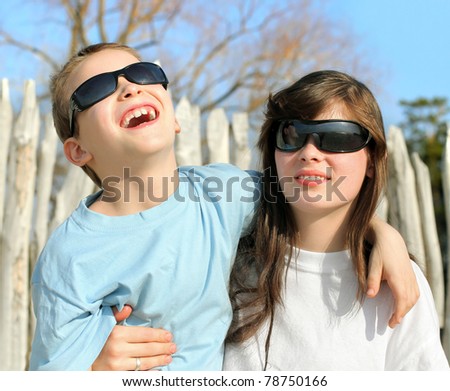 happy brother and sister in sun glasses outdoor