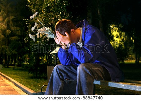 very sad teenager with a flowers in the night park get break an appointment