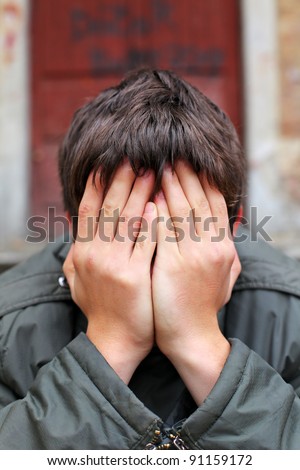 man with hidden face on the old house background