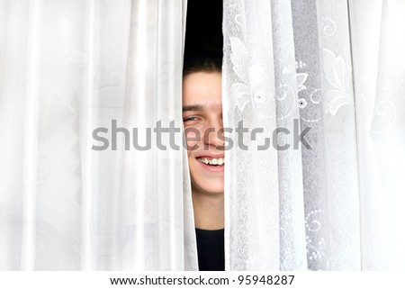 cheerful teenager look out of the curtains