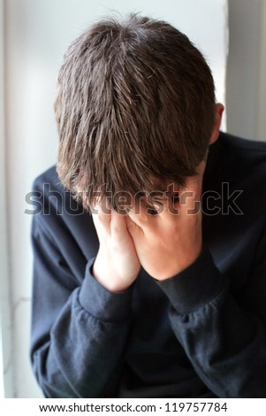 Sorrowful Teenager hide his face