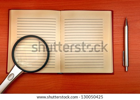 Vintage Writing Pad with Loupe and Pen on the Wooden Background