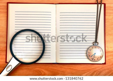 Writing Pad with Loupe and Old Watch on the Wooden Background
