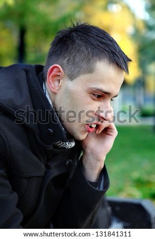 Young Man Talking On Mobile Phone at the Park