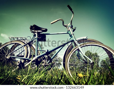 Vintage And Toned Photo Of Two Vintage Bicycles On The Summer Meadow