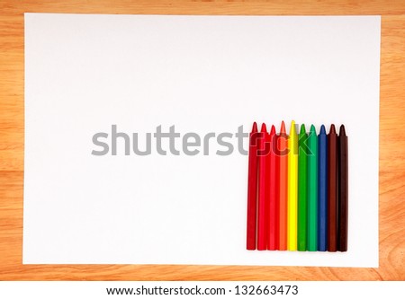 Colored Pencils Kit and Blank Paper on the Wooden Table