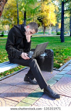 Troubled Man with Laptop at the Autumn Park