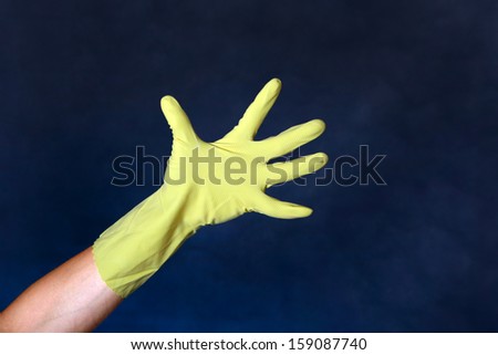 Hand in Rubber Glove on the dark background