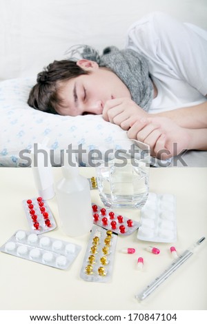 Sick Young Man sleeps with Pills on foreground. Focus on the Pills