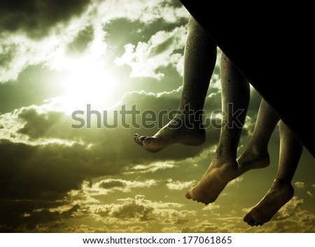 Toned photo of Two legs hanging on Sky Background