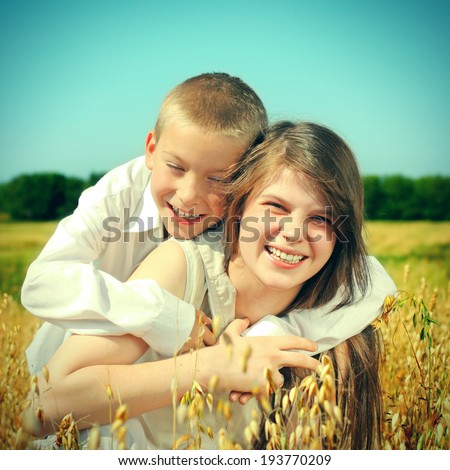 Toned photo of Happy Brother and Sister in the Wheat Field