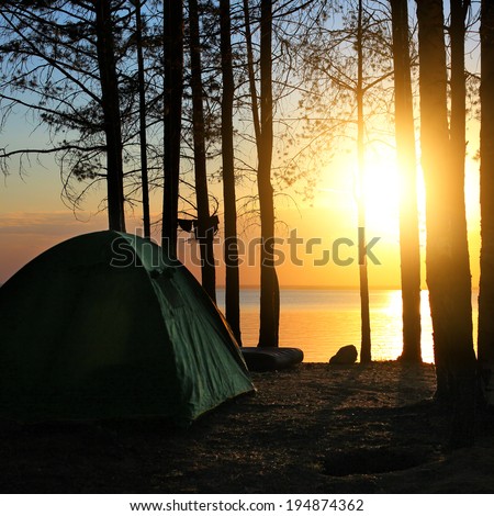 Tent in the Forest at the Seaside on Sunset Background