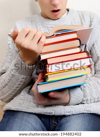Surprised Teenager reads a Book at the Home. Focus on the Books