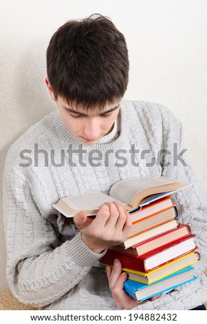 Teenager reads a Books on the Sofa at the Home
