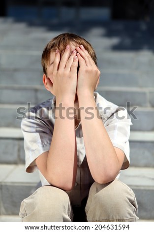 Sad and Troubled Kid sitting on the Stairs outdoor